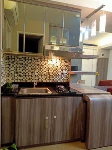 uma cozinha com um lavatório e uma bancada em Apartemen Bassura City by Globy Property em Jakarta