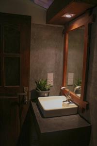 een badkamer met een wastafel en een spiegel bij Cozy Resort in Matara