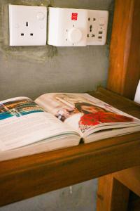een open boek op een houten tafel met een lichtschakelaar bij Cozy Resort in Matara