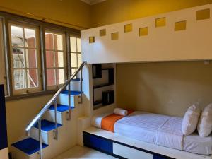 a bedroom with a bunk bed and a staircase at Omah Ngangeni by OTSCA in Ngabean