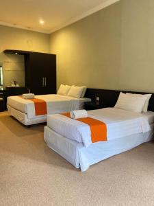 two beds in a hotel room with at Omah Ngangeni by OTSCA in Ngabean