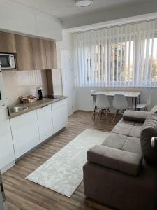 a kitchen and a living room with a couch and a table at OPTIMUM 1 apartment - One bedroom - in core city center in Zenica