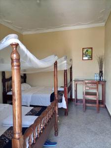 Masindi的住宿－Pross Residence，一间卧室设有两张双层床和一张桌子