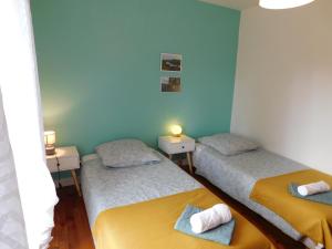 zwei Einzelbetten in einem Zimmer mit blauen Wänden in der Unterkunft Campagne et confort avec piscine chauffée in Carsac-Aillac