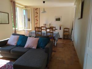 ein Wohnzimmer mit Sofa und Tisch in der Unterkunft Campagne et confort avec piscine chauffée in Carsac-Aillac