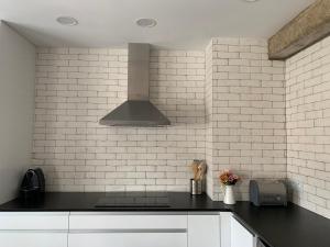 a kitchen with a black counter top and white tiles at Casa Chus in Albarracín +16 photos