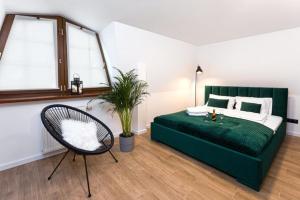 sypialnia z zielonym łóżkiem i krzesłem w obiekcie Apartament Bianco Verde w mieście Częstochowa