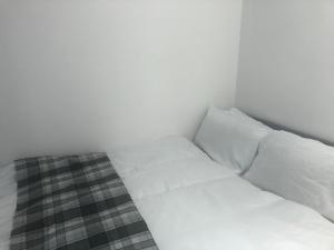 a white bed with two pillows in a room at Macpherson House in Luton