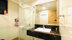 La salle de bains est pourvue d'un lavabo et d'une douche avec un miroir. dans l'établissement J-Double Room Xinzhuang District, à Xinzhuang