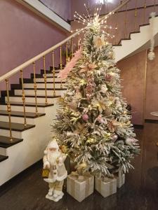 a christmas tree with presents next to a staircase at Nork Hotel in Yerevan