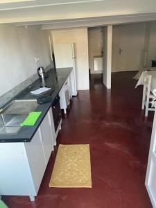 a kitchen with a counter and a red floor at Studio tout confort dans maison de caractère in La Bastide