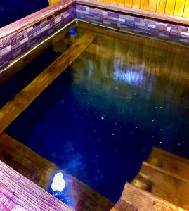 una piscina vacía de agua con suelo de madera en Casa Grai Moroșănesc en Breb