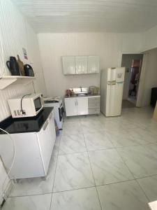a large kitchen with a refrigerator and a sink at Casa do Sussego in Foz do Iguaçu