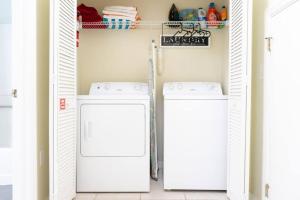 uma lavandaria com duas máquinas de lavar e secar roupa em Resort Home, Private Pool Orlando Disney sleeps12 em Kissimmee