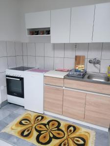 a kitchen with a stove and a sink and a kitchen rug at Apartman Vuk in Pale