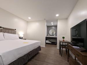 ein Hotelzimmer mit einem Bett und einem Flachbild-TV in der Unterkunft The Honey Bee Motel in Dunlap