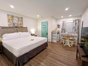 a bedroom with a bed and a table and a kitchen at The Honey Bee Motel in Dunlap