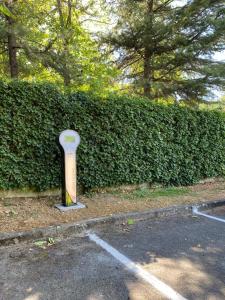 a parking lot with a parking meter in front of a hedge at Park Hotel Chianti in Tavarnelle in Val di Pesa