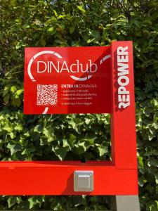 a red sign in front of a bush at Park Hotel Chianti in Tavarnelle Val di Pesa