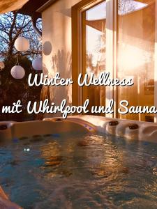 una piscina en una casa con las palabras de la ventana de bienestar de invierno en GartenApartment Strandgut mit Outdoor Whirlpool und Garten en Petershagen