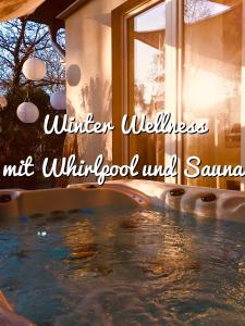 a swimming pool in a house with the words winter wellness winter wellness nut window at GartenApartment Strandgut mit Outdoor Whirlpool und Garten in Petershagen