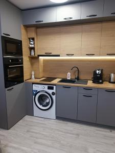 a kitchen with a washing machine and a sink at Апартамент 3 А in Varna City