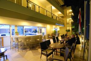 a restaurant with a bar and people sitting at tables at Michel Apartments in Kos