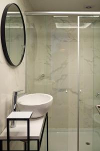 a bathroom with a sink and a mirror at Arena Suites in Mar del Plata +16 photos