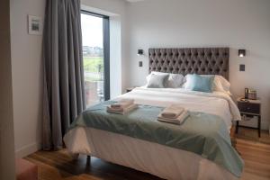 a bedroom with a large bed with a large window at Arena Suites in Mar del Plata