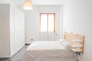 a white bedroom with a bed and a window at 083 - Casa Grande con Attico condominiale vista mare, 500 metri dalla spiaggia in Chiavari