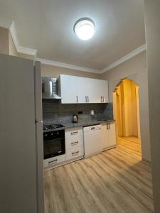 een keuken met witte kasten en een fornuis met oven bij KAKTÜS SUİT in Istanbul