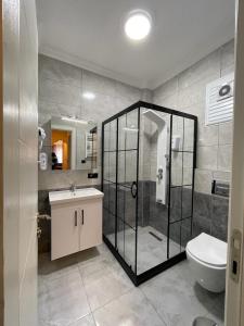 een badkamer met een douche, een toilet en een wastafel bij KAKTÜS SUİT in Istanbul