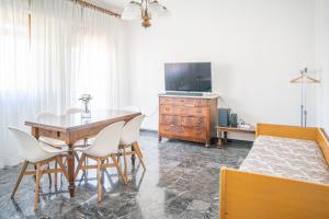 a dining room with a table and a tv at 083 - Casa Grande con Attico condominiale vista mare, 500 metri dalla spiaggia in Chiavari