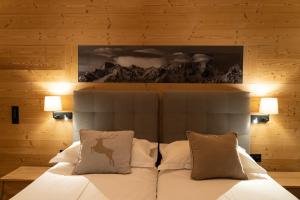 a bedroom with a bed with white sheets and pillows at Hotel Les Chamois in Verbier