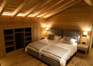 ein Schlafzimmer mit einem großen Bett in einem Holzzimmer in der Unterkunft Hotel Les Chamois in Verbier