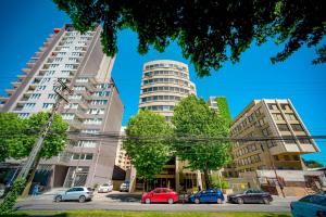 a parking lot with cars parked in front of tall buildings at Hotel Diego de Almagro Concepción in Concepción