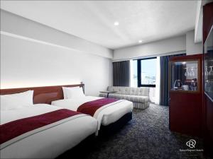 熊本市にあるダイワロイネットホテル熊本銀座通り PREMIER（旧：ダイワロイネットホテル熊本銀座通り）のベッド2台とソファが備わるホテルルームです。