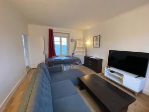a living room with a couch and a flat screen tv at Appartement T4 Cité Cardaillac, Parking Privé, Wifi in Rodez