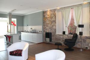 una sala de estar con muebles blancos y una pared de piedra. en Tower Rock Puerto Deseado Superior en Puerto Deseado