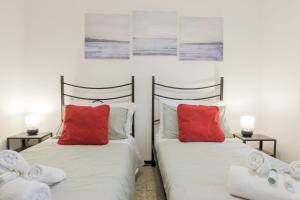 two beds with red pillows in a bedroom at SANTA CROCE GUEST HOUSE in Venice