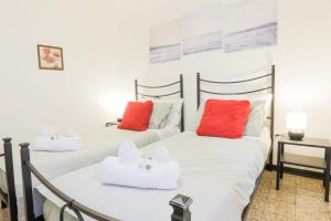 two beds in a room with red and white pillows at SANTA CROCE GUEST HOUSE in Venice