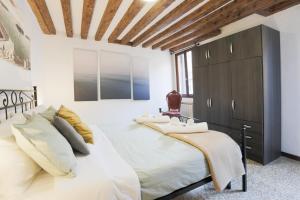 a bedroom with a large white bed with a wooden ceiling at SANTA CROCE GUEST HOUSE in Venice