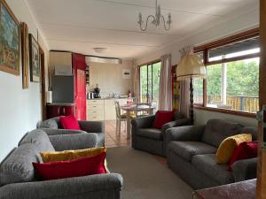 a living room with two couches and a kitchen at Apartment Downstairs Sedgefield in Sedgefield