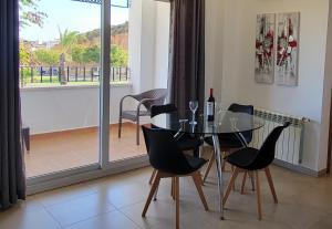 Un comedor con mesa y sillas y un balcón. en Apartamento Atlantico, en Sucina