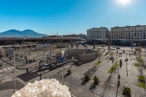 una plaza de la ciudad con una estación de autobuses y edificios en Bella Napoli Suites, en Nápoles