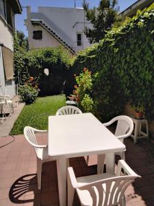 a white table and chairs on a patio at Maria Delicia in Godoy Cruz