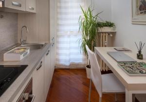 una cucina con lavandino e tavolo con sedie di DESIGN DISTRICT- NAVIGLI Mini Appartamento Via Tortona 66 a Milano