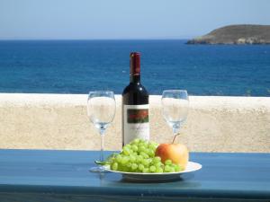 a plate of grapes and wine glasses on a table at Blue & Sea Studios Apartments in Drios