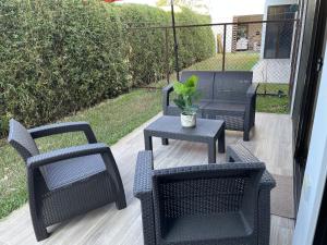 a patio with four chairs and a table with a potted plant at Perfect combination between nature and fun in Jacó