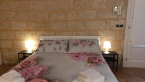 Un dormitorio con una cama con flores rosas y almohadas en Villino Tronchetto Bianco, en Mola di Bari